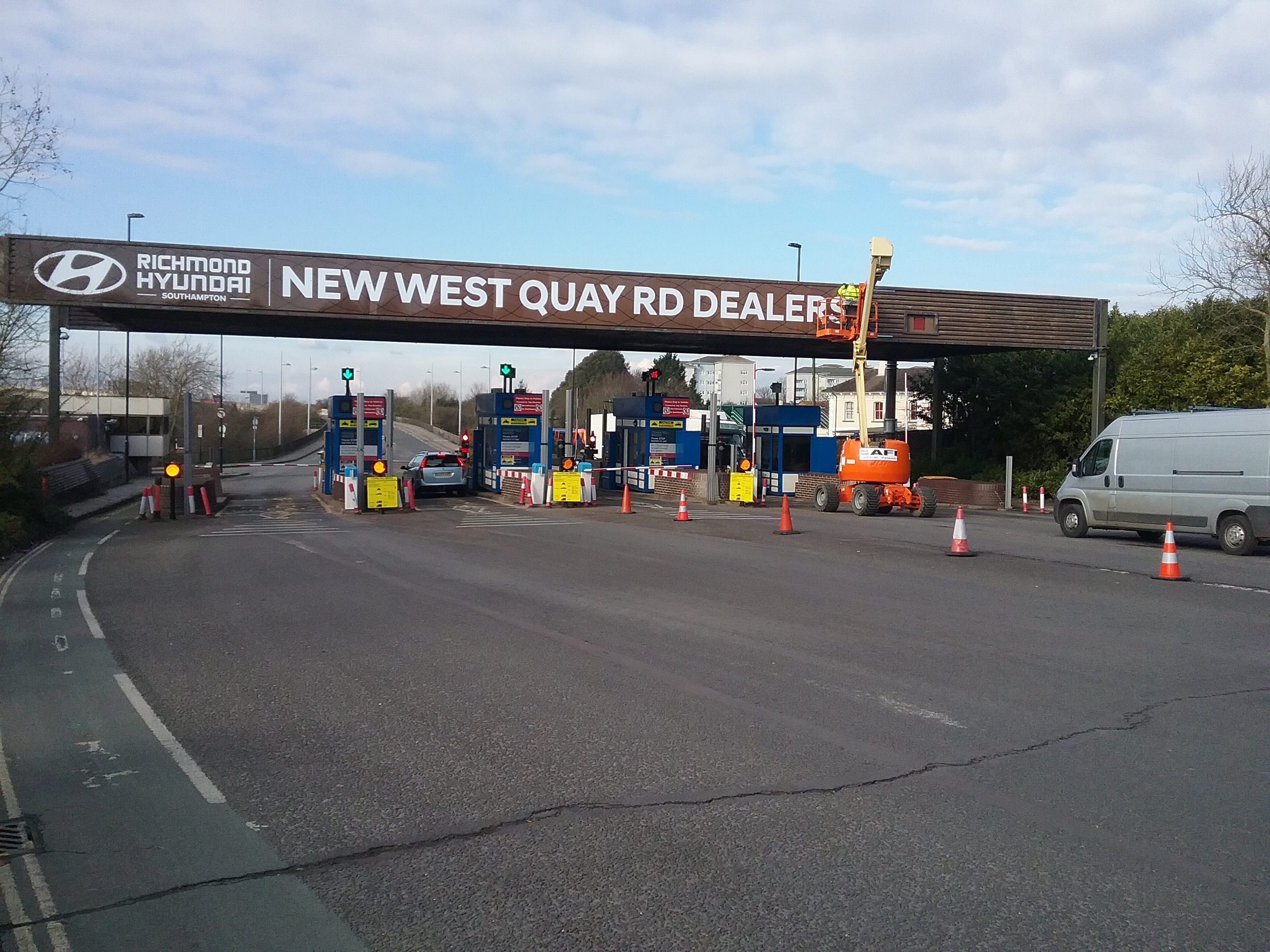 A large format sign being installed by our fully trained sign fitter using a cherry picker, over a toll bridge
