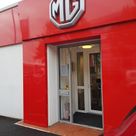 A car sales forecourt decorated entrance with coloured aluminium composite panels and raised off logo