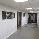A corridor of a gym with raised letters on door and on tray sign